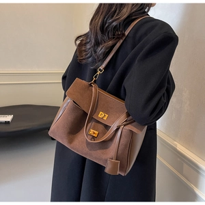 Détail du sac cabas vintage en daim marron avec double fermoirs pivotants en métal