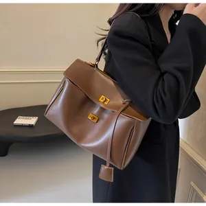 Détail du sac cabas en daim marron café avec fermoirs rotatifs en métal doré et rabat