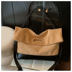 Detail of vintage large capacity tote bag with khaki suede and black leather patchwork