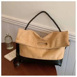 Detail of vintage tote bag showing contrasting brown suede and black leather textures