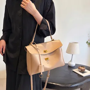 Beige leather handbag with golden twist locks and adjustable strap for elegant women
