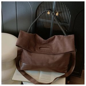 Detail of vintage tote bag featuring mixed suede and leather texture with woven handle