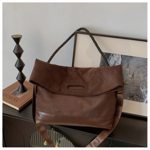 Detail of dark brown suede shoulder bag with thick rope strap and leather trim design