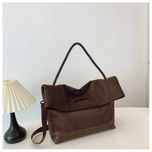 Detail view of coffee suede tote bag with black twisted rope handle and leather base