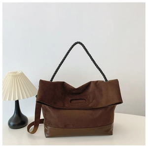 Detail of vintage brown suede tote bag with black textured rope handle and leather base