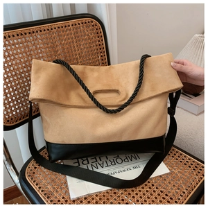 Detail of a color-block tote bag with a braided rope handle on a vintage chair