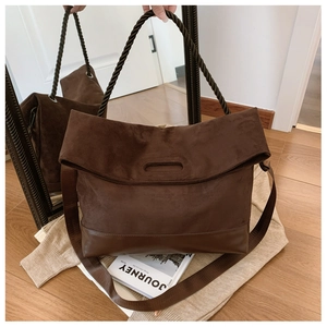 Detail of dark coffee suede tote bag with woven rope handle and wide leather shoulder strap