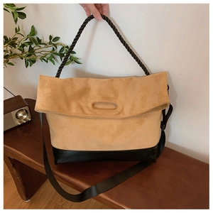 Detail of large tote bag with camel suede upper and black leather bottom contrast