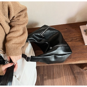 Close-up of black retro tote bag with soft pleated PU leather and silver zippers