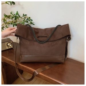 Detail of vintage brown suede tote with leather base and woven rope handle accents