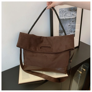 Detail of coffee brown tote with woven rope handle and suede leather stitching textures