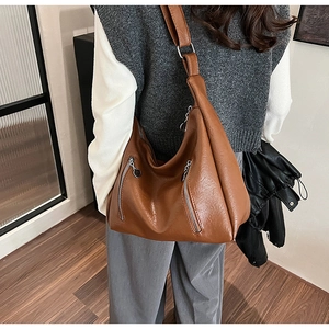 Close-up of brown large-capacity PU leather shoulder bag with metallic zipper details