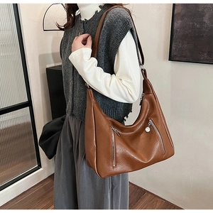 Detail of a brown PU leather hobo bag featuring double silver zippers and a minimalist design