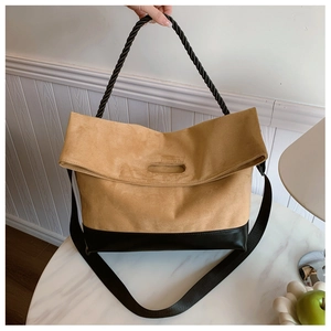 Detail of retro dual-tone tote bag with khaki suede and black leather stitching