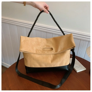 Close-up of contrast tote bag featuring yellow suede and black leather textures