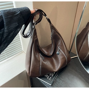 Macro detail of retro dark brown PU leather hobo bag with multiple zipper pockets