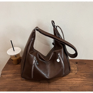 Detailed close-up of dark brown vintage tote bag featuring side zippers and metal pendants