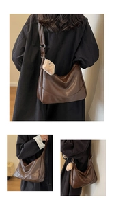 Detail view of large brown vintage PU leather tote bag with cute plush bear keychain charm
