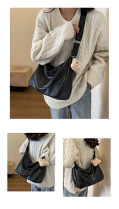 Detail of black matte leather tote bag with wide strap and plush bear charm accessory