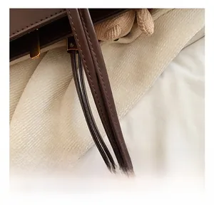 Detail showing comfortable dark brown leather handle with golden metal hardware and stitching