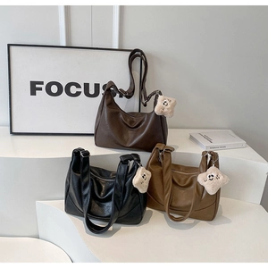 Close-up of large PU leather tote bags in three colors with plush star pendants