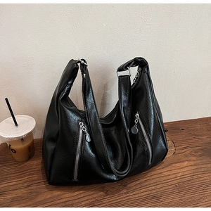 Detail of black lychee grain PU leather hobo bag with multiple silver zipper pockets