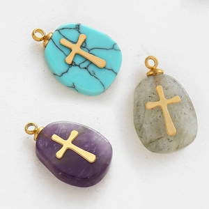 Pendentifs en pierre goutte d'eau avec croix éclair et anneaux dorés sur fond gris