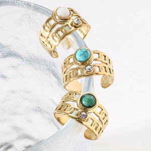 Detail of vintage gold-plated wide rings with natural stone and zircon on glass rim