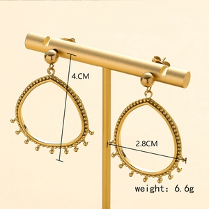 Détail de boucles d'oreilles larmes dorées évidées de 4 cm sur présentoir avec dimensions