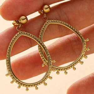 Boucles d'oreilles goutte évidées en acier doré 14K avec détails de bordure perlée