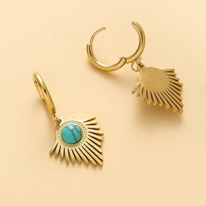 Détail de boucles d'oreilles triangle dorées avec pierre turquoise et fermoirs charnière