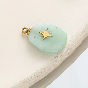 Detail of light green natural stone pendant with a gold star inlay and polished metal loop