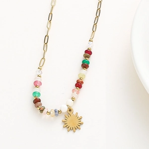 Détail macro du collier bohème avec pierres colorées et pendentif soleil