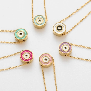 Detail of colorful round evil eye pendants with golden sunburst texture and fine chain