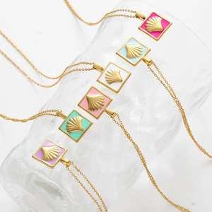 Detailed close-up of six colorful enamel scallop pendants on gold chains over textured glass