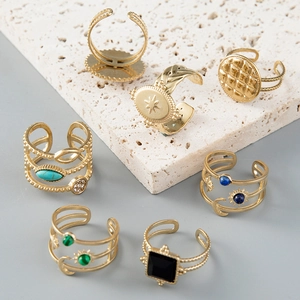 Gold celestial rings set with moon and sun patterns and decorative stones