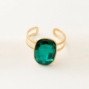 Detail of vintage gold open ring featuring a large faceted green stone and beaded texture