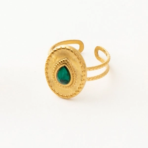 Detail of bohemian gold ring with teardrop green stone and filigree metal patterns