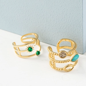 Detailed shot of two 18k gold plated open rings with malachite and turquoise insets