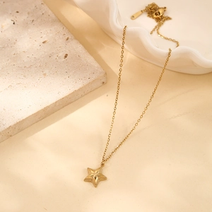 Detailed close-up of a gold-plated starfish pendant on a fine stainless steel chain