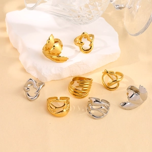 Close-up of irregular 18K gold and silver stainless steel rings with molten lava design