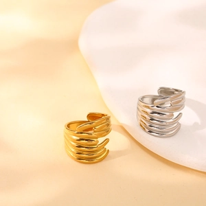 Detailed view of layered wavy claw rings in polished 18K gold and silver steel finish