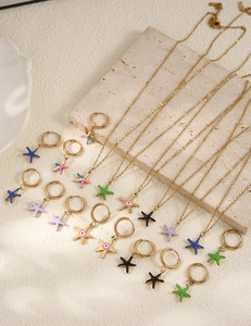 Detailed view of colorful starfish necklaces and gold earrings on a stone display