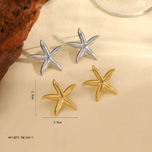Dettaglio degli orecchini a stella marina oro e argento con misure su sfondo sabbia