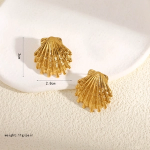 Vista macro di orecchini a conchiglia dorati con dettagli delle dimensioni 3 cm x 2,8 cm