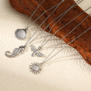 Bohemian silver necklace set featuring seashell, seahorse, bee, and sun pendants