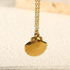 Close-up of golden shell pendant necklace with detailed radial texture and sturdy chain