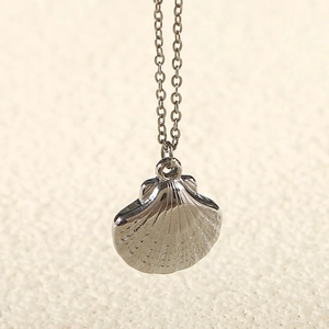 Macro view of polished silver shell pendant with detailed O-chain necklace