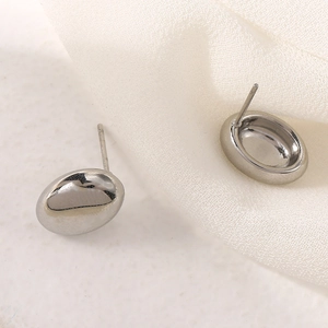 Macro view of polished silver water drop stud earrings with reflective mirror finish