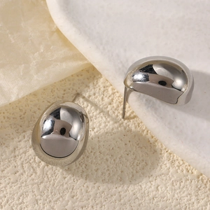 Macro view of polished silver water drop earrings with smooth metallic mirror finish